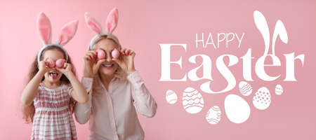 Happy little girl and her grandmother with bunny ears and Easter eggs on pink background