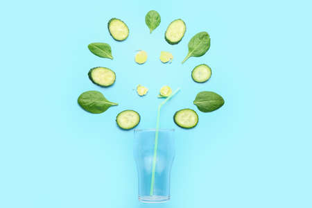 Composition with green vegetables and empty glass on blue backgroundの写真素材