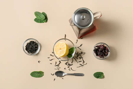 Composition of teapot with tasty tea and glass with lemon on yellow backgroundの写真素材