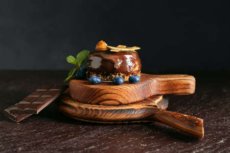 Board with delicious chocolate cake and blueberries on dark backgroundの写真素材