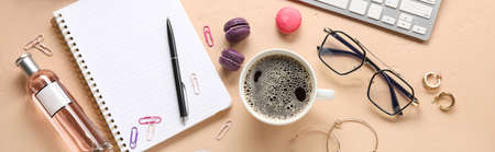 Cup of coffee with female accessories and office supplies on color backgroundの写真素材
