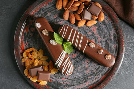 Plate with delicious chocolate cakes, almonds and raisins on dark backgroundの写真素材