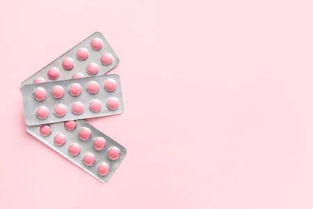 Blister packs with pills on pink backgroundの写真素材