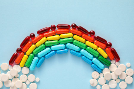 Rainbow made of pills and capsules on color backgroundの写真素材