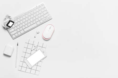 Composition with mobile phone, keyboard and modern gadgets on white backgroundの写真素材