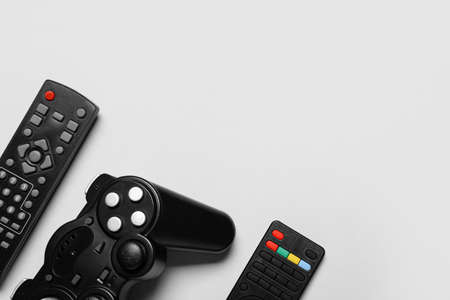 Joystick and remote controllers on white background, closeup