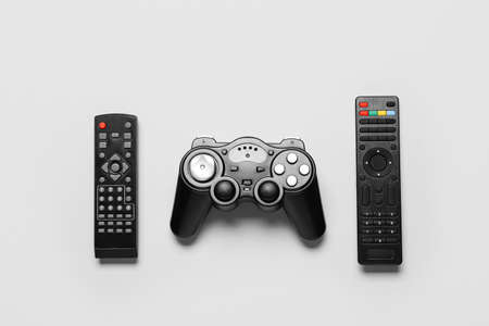 Joystick and remote controllers on white background
