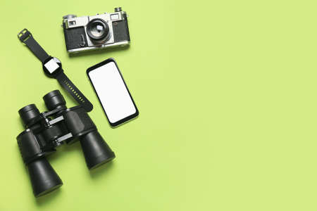 Mobile phone, binoculars, smart watch and photo camera on green backgroundの写真素材