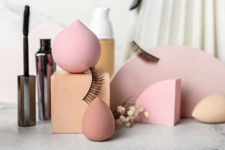 Different makeup sponges and cosmetics on light background, closeupの写真素材