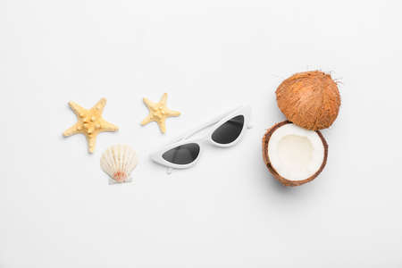 Stylish sunglasses, ripe coconut and starfishes on white backgroundの写真素材