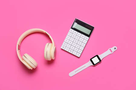 Headphones, calculator and smart watch on pink backgroundの写真素材