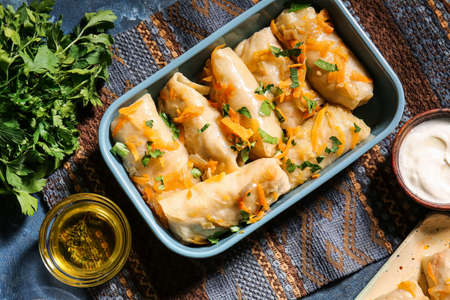 Baking dish with tasty stuffed cabbage rolls on color backgroundの写真素材