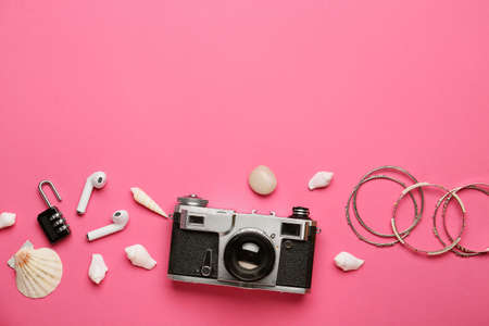 Composition with photo camera, earphones, female accessories and seashells on color backgroundの写真素材
