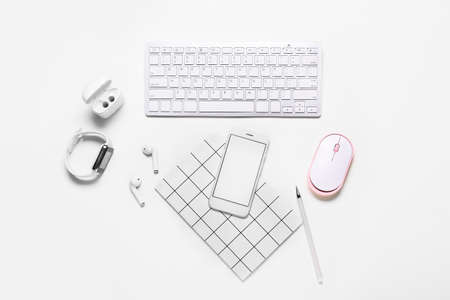 Composition with mobile phone, keyboard and modern gadgets on white backgroundの写真素材