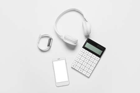 Mobile phone, smart watch, headphones and calculator on white backgroundの写真素材