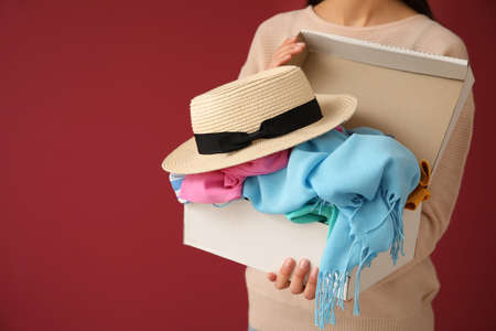 Woman and wardrobe box with clothes on color backgroundの写真素材
