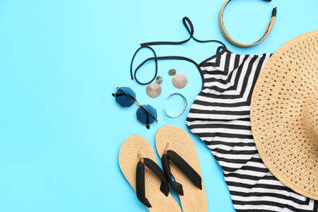 Composition with beach accessories and stylish swimsuit on color background