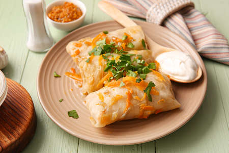 Plate with tasty stuffed cabbage rolls on color wooden backgroundの写真素材