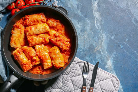 Frying pan with tasty stuffed cabbage rolls on color backgroundの写真素材