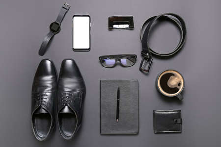 Set of male accessories, mobile phone and cup of coffee on dark backgroundの写真素材