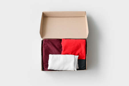 Wardrobe box with clothes on light background