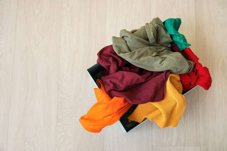 Wardrobe box with clothes on wooden background
