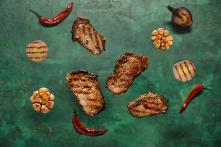 Flying beef brisket and vegetables on color backgroundの写真素材