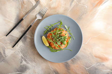 Delicious salmon tartar on grunge background
