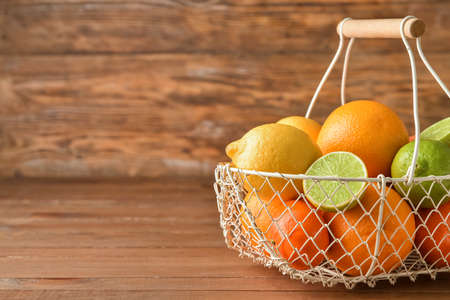 Basket with healthy citrus fruits on wooden backgroundの写真素材