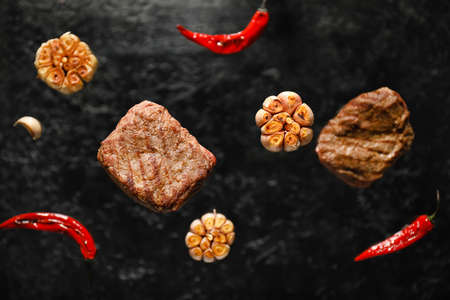 Tasty beef brisket with spices on dark background