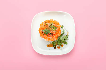 Delicious salmon tartar on color background