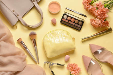Stylish bag, decorative cosmetics and flowers on color backgroundの写真素材