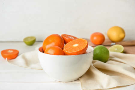 Bowl with healthy citrus fruits on light wooden backgroundの写真素材