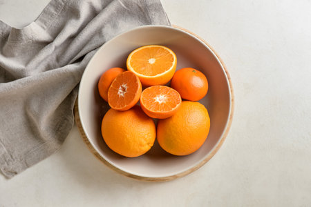 Plate with healthy oranges and tangerines on light backgroundの写真素材