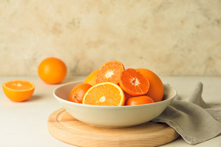 Plate with healthy oranges and tangerines on light backgroundの写真素材