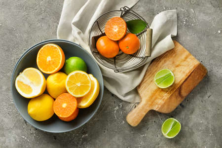Bowl with healthy citrus fruits on gray backgroundの写真素材
