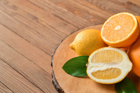 Board with healthy citrus fruits on wooden backgroundの写真素材