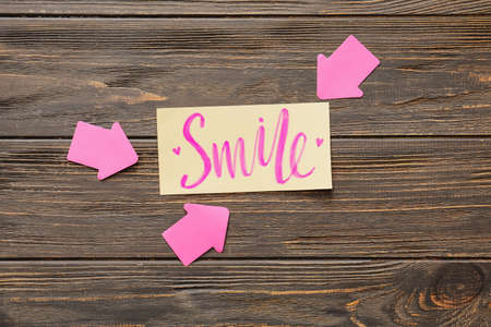 Word SMILE with arrows on wooden backgroundの写真素材