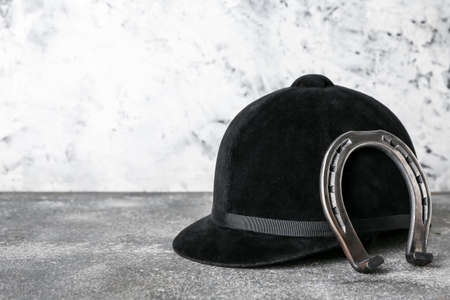 Horse riding helmet and horseshoe on grunge backgroundの写真素材