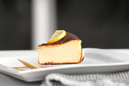 Plate with slice of tasty Basque burnt cheesecake on table, closeupの写真素材