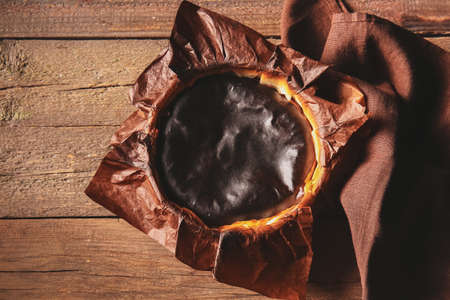 Tasty Basque burnt cheesecake on wooden background