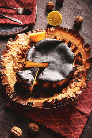 Tasty Basque burnt cheesecake on dark background
