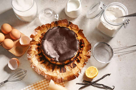 Tasty Basque burnt cheesecake with ingredients on light backgroundの写真素材