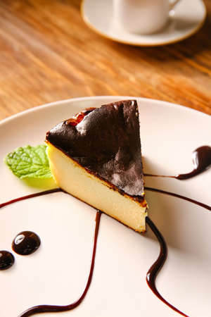 Plate with slice of tasty Basque burnt cheesecake on table, closeupの写真素材