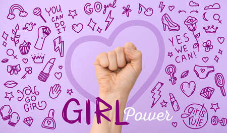 Hand of woman with clenched fist and text GIRL POWER on color background. International Women's Day celebrationの写真素材