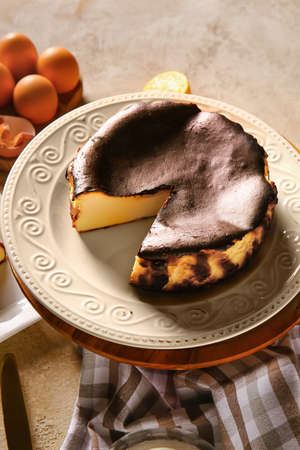 Dessert stand with tasty Basque burnt cheesecake on grunge background