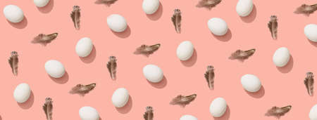 Easter eggs with feathers on pink backgroundの写真素材