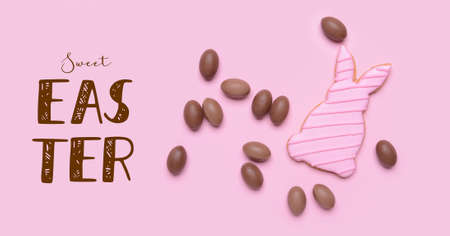 Tasty chocolate eggs and bunny cookies on pink background. happy easter celebration