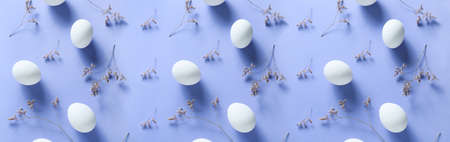 Easter eggs with flowers on lilac backgroundの写真素材