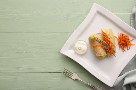 Plate with tasty stuffed cabbage rolls on color wooden background